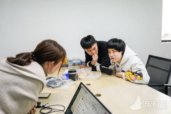 图为马寅青在与同事们讨论问题